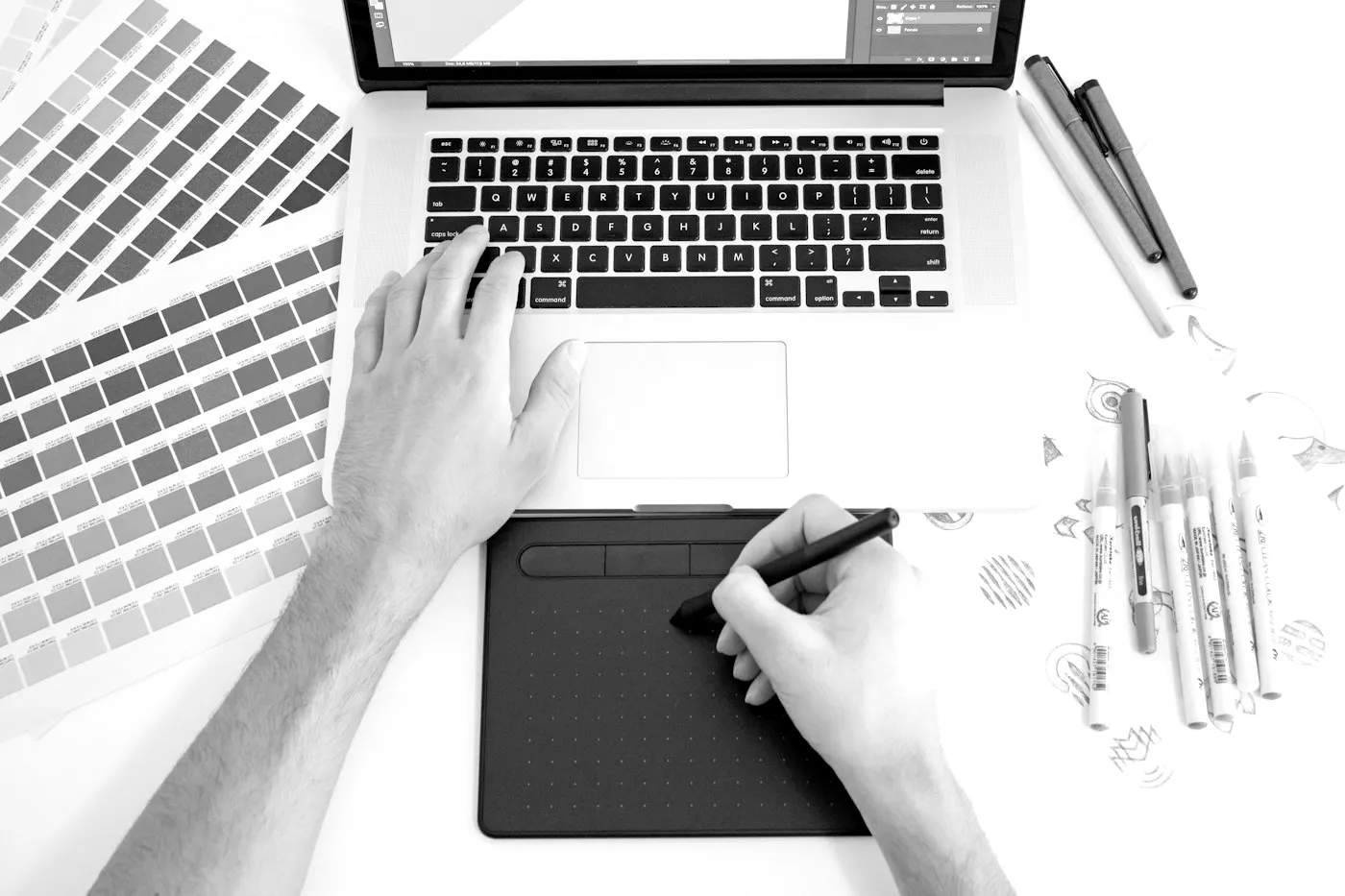 Diseñadora trabajando con tableta gráfica y guía de color