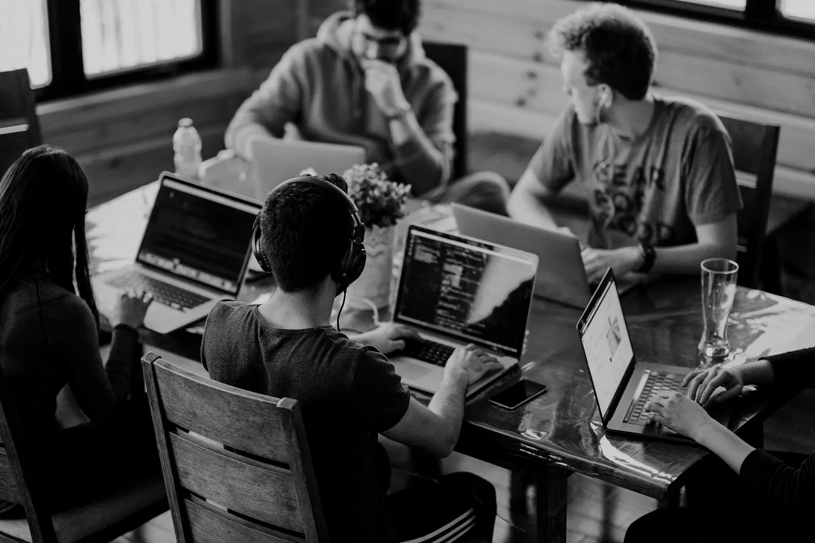 Equipo de trabajo colaborando alrededor de una mesa con computadoras