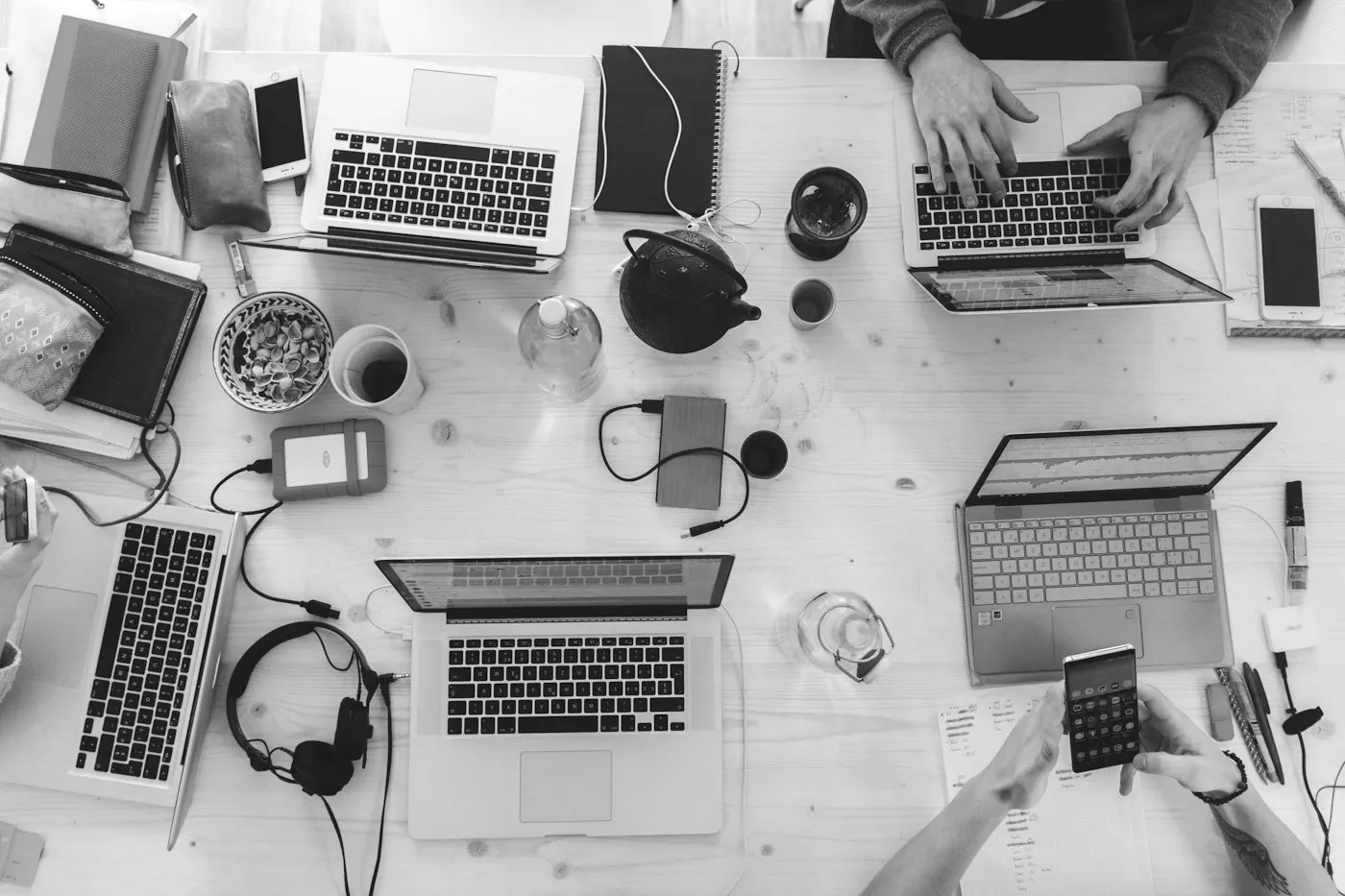 Mesa de trabajo vista desde arriba con computadoras y teléfonos